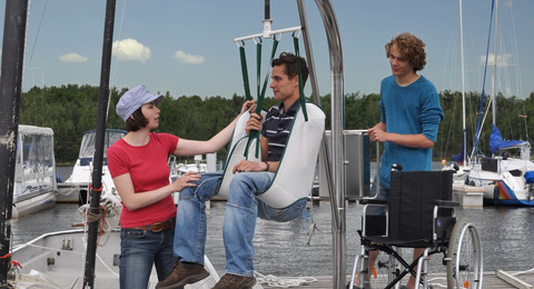 Hafencamp Senftenberger See Gast wird im Lift sicher in ein Segelboot gesetzt