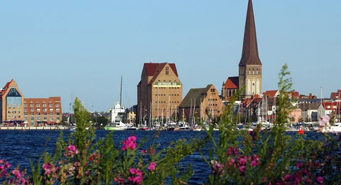 Blick auf den Rostocker Stadthafen mit der Petrikirche und Speichergebäuden auf der Holzhalbinsel.