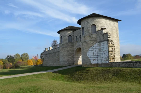 Nordtor des Kastells Weißenburg umgeben von Wiese und Bäumen