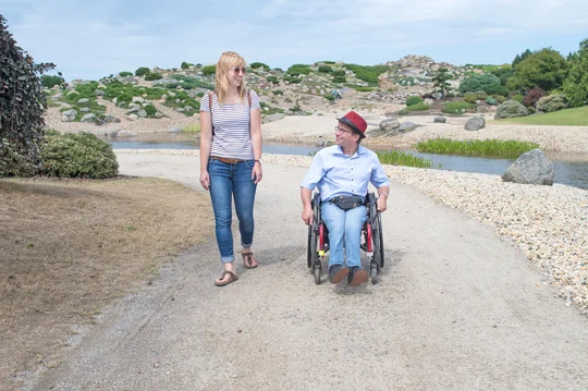 Findlingspark Nochten Frau und Mann im Rollstuhl spazieren durch den Findlingspark