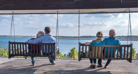 Besucher sitzen auf Schaukeln vor dem Großräschener See