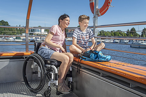 Mutter im Rollstuhl und Sohn auf dem Fahrgastschiff im Stadthafen Senftenberg