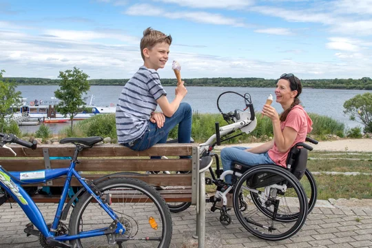 Der Senftenberger See kann auf einem breiten, autofreien Seerundweg mit Handbikes und Fahrrädern umfahren werden. An der Anlegestelle in Großkoschen gibt es leckeres Eis. Der Senftenberger See kann auf einem breiten, autofreien Seerundweg mit Handbikes und Fahrrädern umfahren werden. An der Anlegestelle in Großkoschen gibt es leckeres Eis.