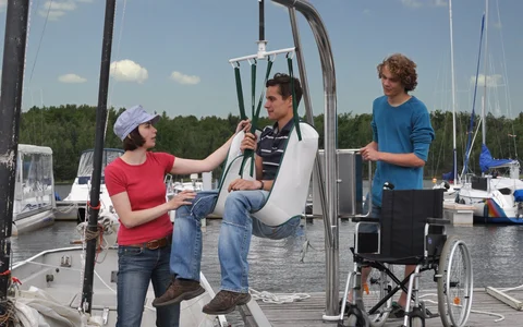 Hafencamp Senftenberger See Gast wird im Lift sicher in ein Segelboot gesetzt
