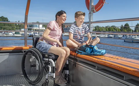 Fahrgastschiff AquaPhönix am Stadthafen Senftenberg Mutter im Rollstuhl und Sohn auf dem Fahrgastschiff im Stadthafen Senftenberg