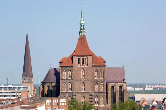 Die mächtige Marienkirche befindet sich im Herzen der Rostocker Innenstadt. Im Hintergrund zu sehen ist der Aussichtsturm der Petrikirche in der Östlichen Altstadt. Die mächtige Marienkirche befindet sich im Herzen der Rostocker Innenstadt. Im Hintergrund zu sehen ist der Aussichtsturm der Petrikirche in der Östlichen Altstadt.
