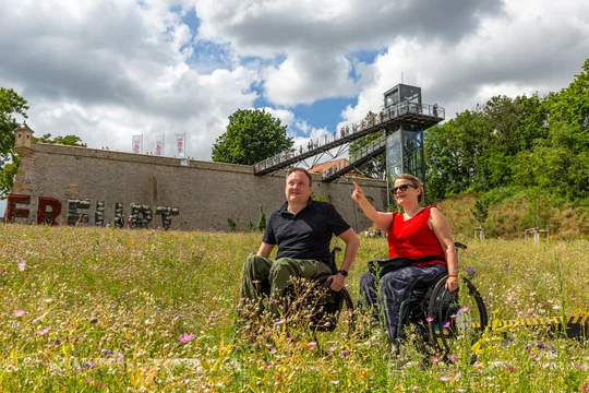 Rollstuhlfahrer auf dem barrierefreien Panoramaweg, der zur Festungsmauer der Zitadelle Petersberg führt. Rollstuhlfahrer auf dem barrierefreien Panoramaweg, der zur Festungsmauer der Zitadelle Petersberg führt.