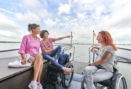 Bootsfahrt mit der MS Altmühlsee Drei Frauen, davon zwei im Rollstuhl, machen eine Bootsfahrt mit der MS Altmühlsee und unterhalten sich.