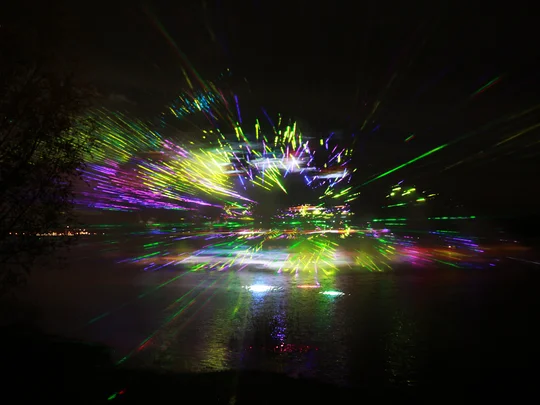 Magische Momente 1 Bunte Laserlichtshow im Dunkeln spiegelt sich im Wasser
