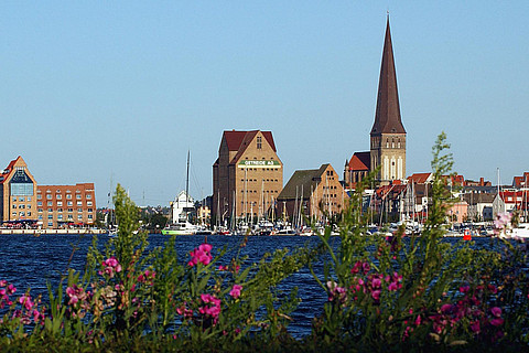 Blick auf den Rostocker Stadthafen mit der Petrikirche und Speichergebäuden auf der Holzhalbinsel.