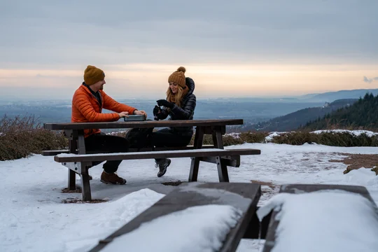 Wandern und Genuss gehören an der Südlichen Weinstraße zusammen. Foto: Südliche Weinstrasse e.V., Thorsten Günthert Paar beim Winterpicknick mit Aussicht