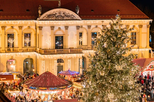 Weichnachtlich geschmückter und Beleuchteter Weihnachtsbaum im fordergrund des Rathauses